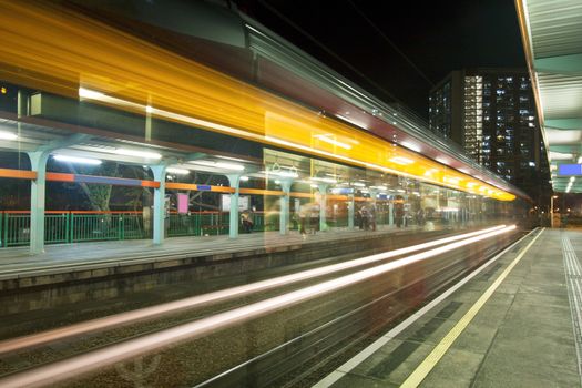 Light rail in Hong Kong at night, busy traffic. 