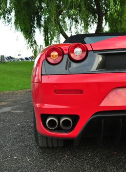 Half rear vew of red speed car in natural background