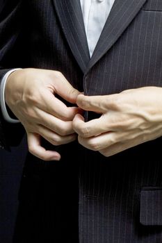 Business man tidy up his suit's button, makes a neat image.