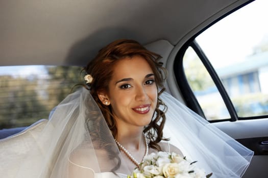 The beautiful smiling bride in the automobile