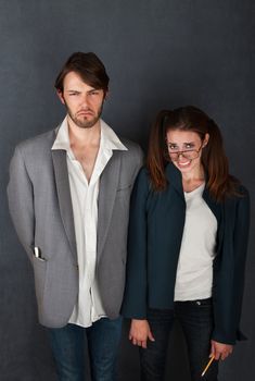 Uncomfortable nerd man and woman couple on gray background