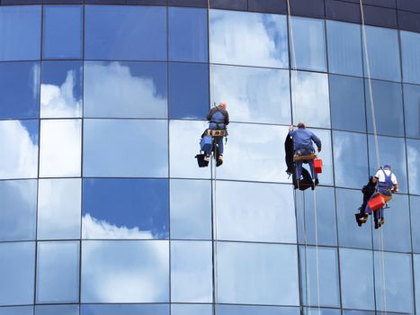 Workers of steeplejack washing a skyscraper windows