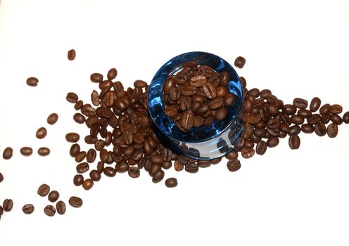 macro shot of coffee beans and a small blue glass container silo 