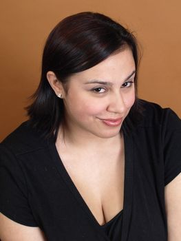 A beautiful young woman isolated against a brown background.