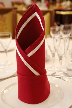 Table with glass and napkin on plate in restaurant