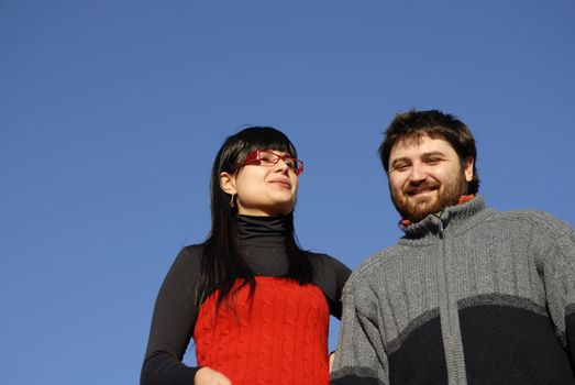 young happy couple with the sky as background