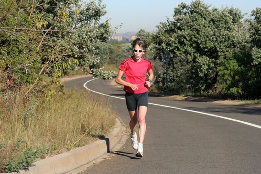 Female athlete in red running fast.