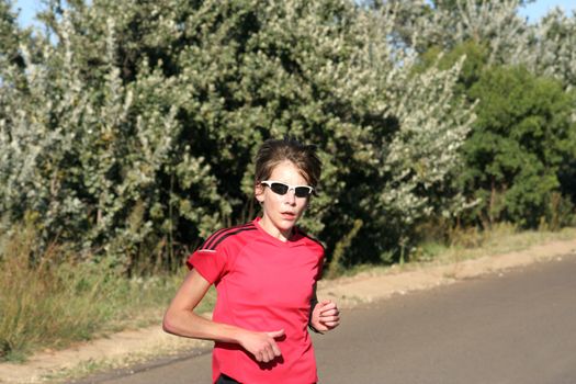 Female athlete in red running fast.