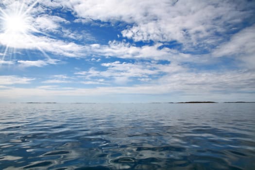 Blue sky and clouds with still ocean