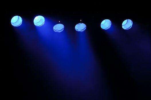 Lights and smoke. Row of blue spotlights from a stage.