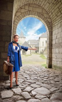 young woman dressed in retro style with an old suitcase