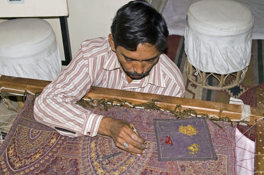 Craftsman attaching sequins to a shawl in Jaipur, Rajasthan, India