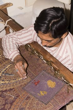 Craftsman attaching sequins to a shawl in Jaipur, Rajasthan, India