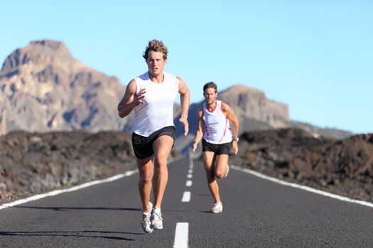 Sport running. Male Runners on road in endurance run outdoors in beautiful landscape - two men.