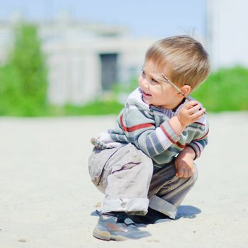 The cute boy plaing on a sand