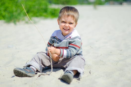 The cute boy plaing on a sand