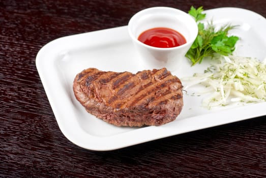 Juicy roasted beef steak with vegetables closeup at plate