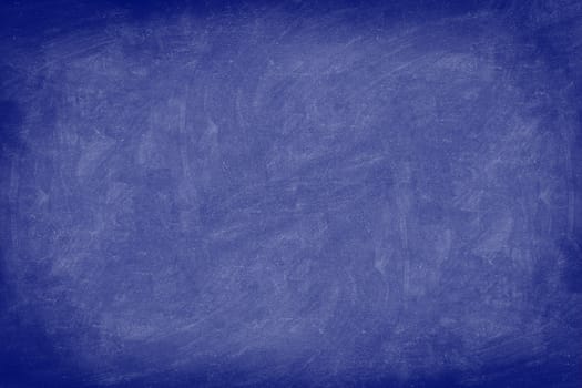 Chalkboard / dark blue blackboard texture background. Used feel, textured with chalk traces. Photo.