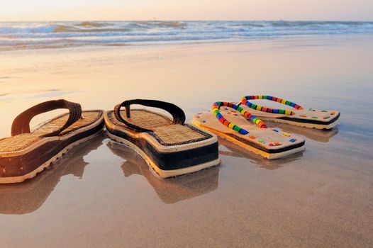 Beach sandals on the wet sandy shore