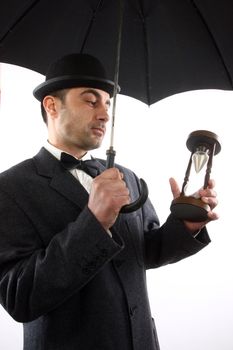 man with bowler hat ,  umbrella  and hour- glass