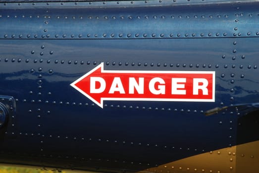 red danger sign painted on a blue background
