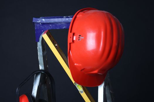 Red helmet on step ladder over black 