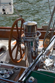 Rudder and coffee cup on a wooden boat 