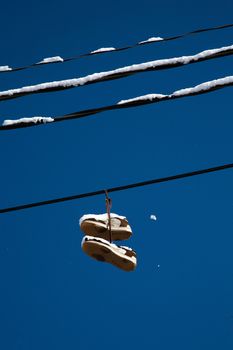 Shoes hanging high on wire