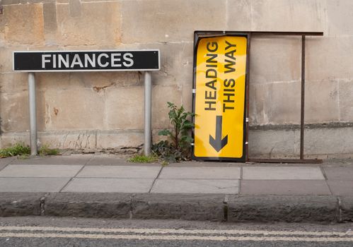 Financial concept involving British signage words on a pavement with block wall behind