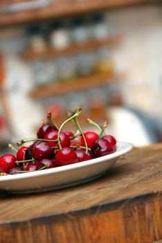 heap of fresh appetizing red cherries on plate indoors