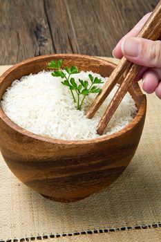 uncooked rice grains in wood bowl 