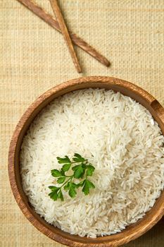 uncooked rice grains in wood bowl 