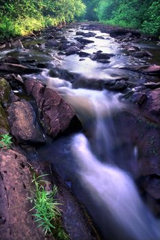 Sunlight gleams off the smooth waters of a stream nestled in the Porcupine Mountains Wilderness State Park of Michigan.