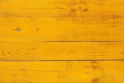 Detail of wooden fence. Four horizontal boards freshly painted  in bright yellow