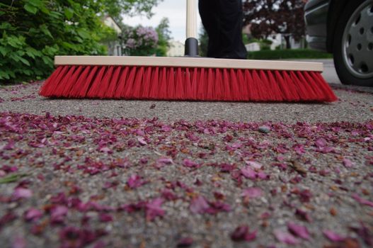 sweeping the sidewalk with a broom