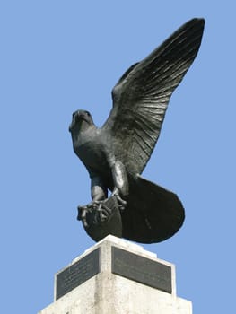 Proud eagle statue against blue sky