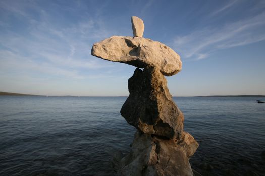 Cross, rocks stacked one one top of another on beach