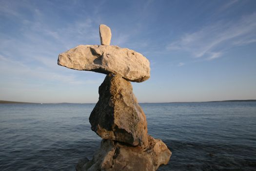 Cross, rocks stacked one one top of another on beach