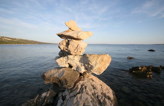 Cross, rocks stacked one one top of another on beach