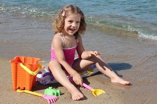 happy little girl playing on beach