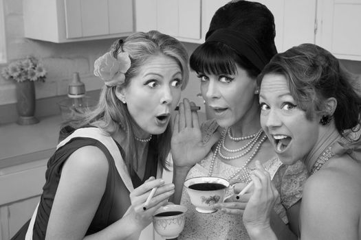 Three shocked women smoking and having coffee 