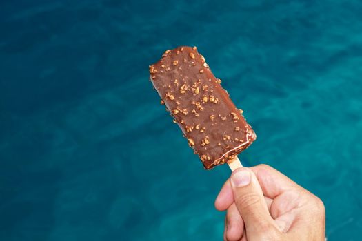 popsicle against a swimming pool on a hot day