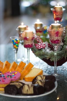 Christmas decoration with candle lights and cakes on the table