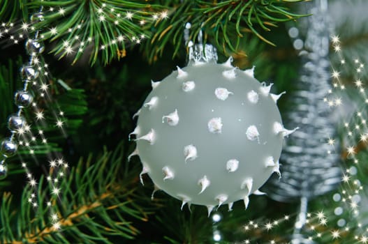 Beautiful Christmas tree toys opaque glass ball with needles on a Christmas tree branch