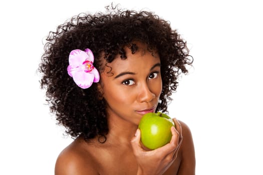 Beautiful happy woman with orchid flower in curly hair eating healthy green apple, isolated.