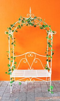 Decorated white romantic vintage chair with orange wall