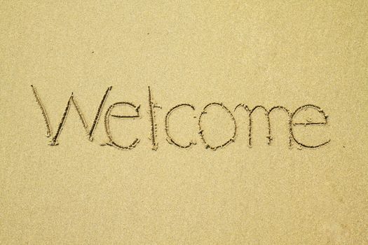 Welcome written on sand at the beach