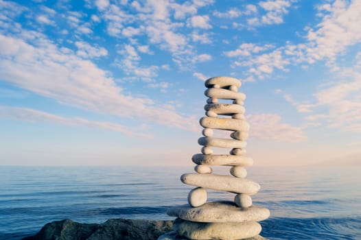 Stack of zen stones on a sky and sea background