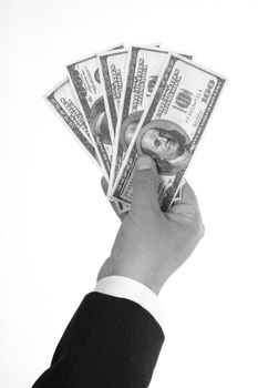 Man's hand holding dollar bills over white. Black and white picture