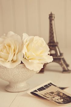 Antique roses with old photos on table